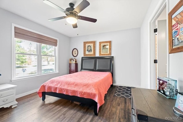 bedroom with a ceiling fan, dark wood-type flooring, and baseboards