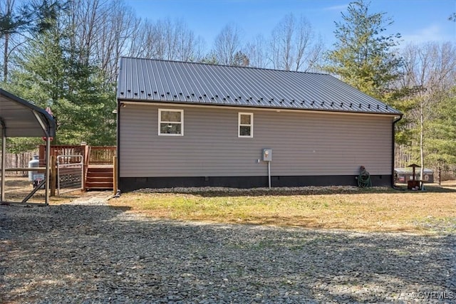 view of property exterior with crawl space, metal roof, and a deck