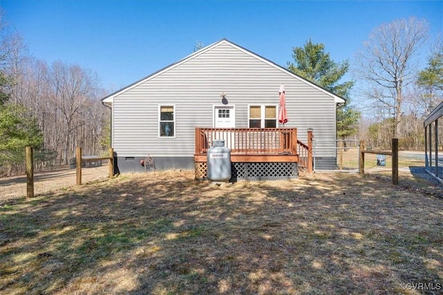 back of property with crawl space, a deck, and fence