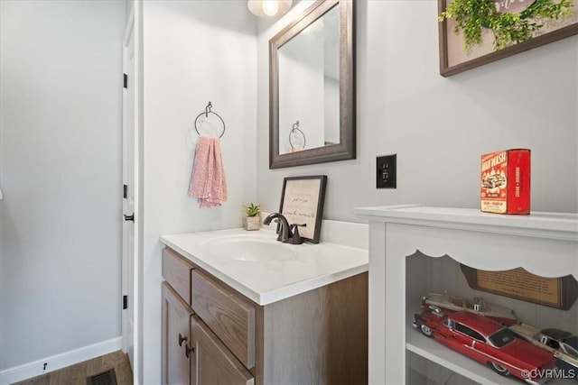 bathroom featuring visible vents, vanity, and baseboards