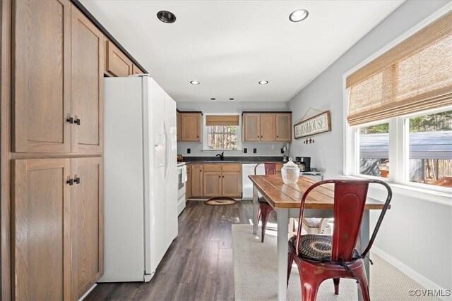 kitchen featuring white appliances, baseboards, recessed lighting, a sink, and dark wood-type flooring