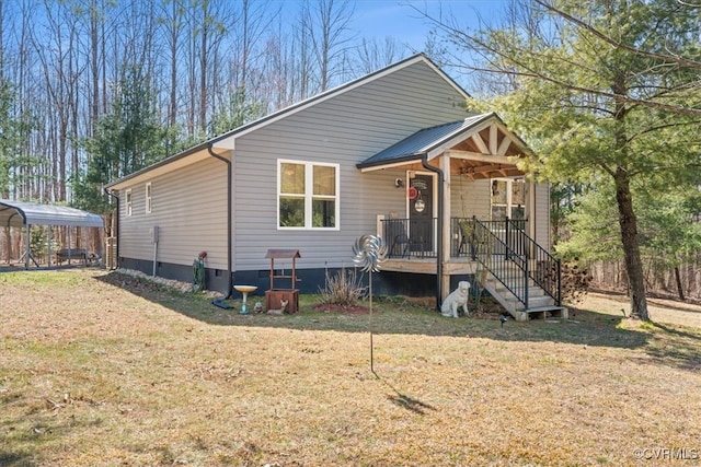 view of front facade featuring a detached carport, metal roof, and a front yard