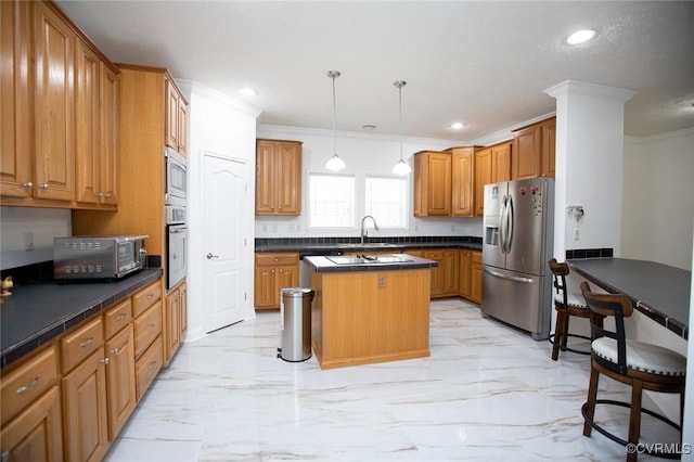 kitchen with marble finish floor, ornamental molding, dark countertops, a center island, and stainless steel appliances