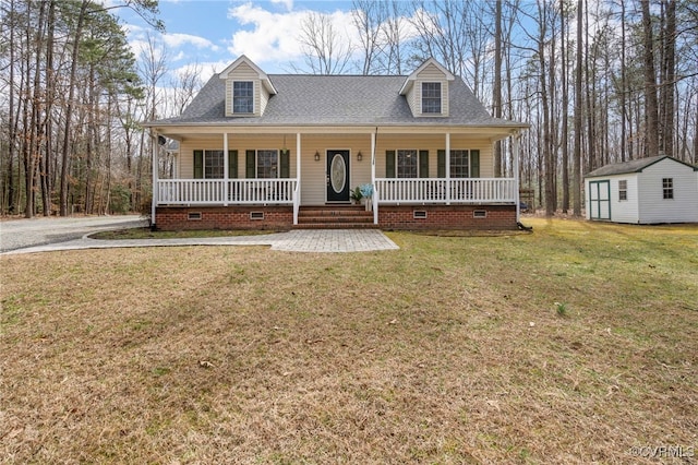 cape cod home featuring an outbuilding, covered porch, a front yard, a shingled roof, and crawl space