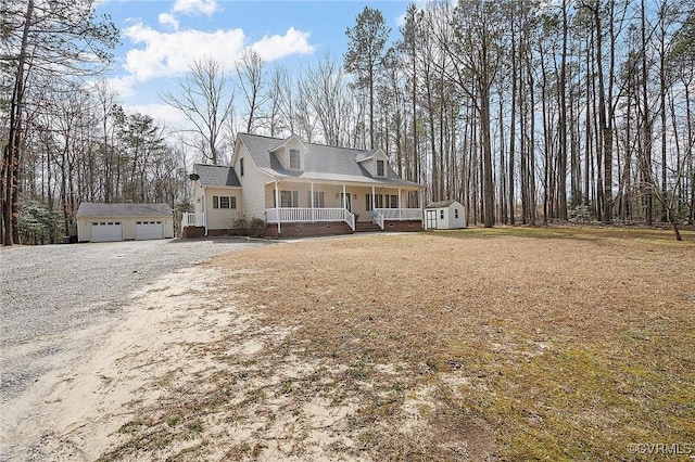 view of front of home featuring a garage, covered porch, driveway, and an outdoor structure