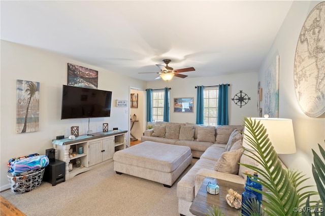 carpeted living area with ceiling fan