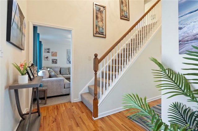 staircase with baseboards and wood finished floors