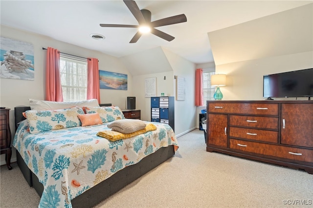 bedroom featuring visible vents, baseboards, lofted ceiling, light carpet, and a ceiling fan