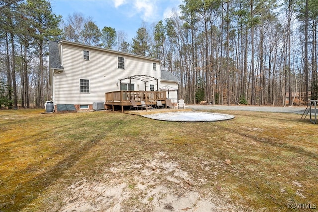 rear view of property featuring central AC unit, a pergola, a patio area, a deck, and a lawn