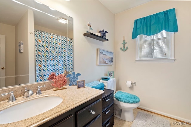 bathroom with vanity, curtained shower, toilet, and baseboards