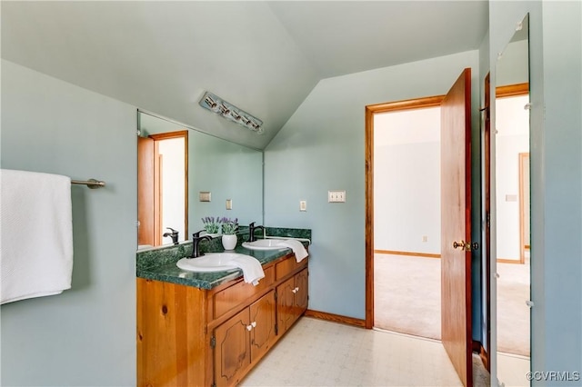 bathroom with lofted ceiling, double vanity, tile patterned floors, and a sink