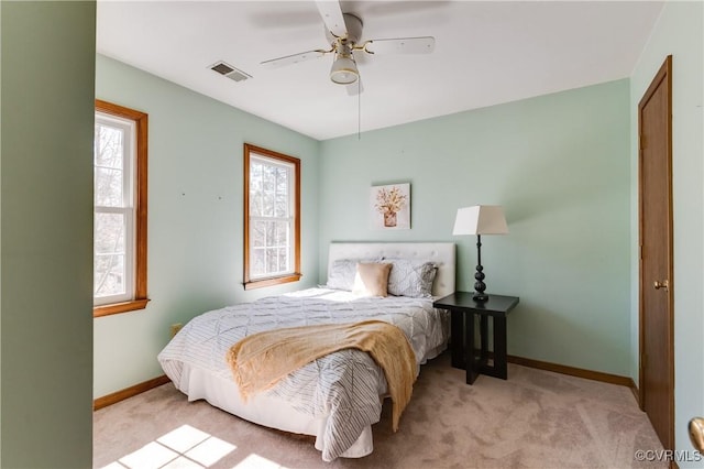 carpeted bedroom with visible vents, baseboards, and ceiling fan