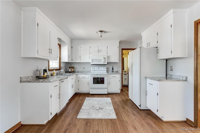 kitchen featuring wood finished floors, white appliances, white cabinetry, and a sink