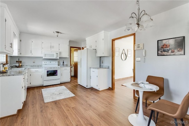 kitchen with white appliances, an inviting chandelier, a sink, white cabinets, and light wood-type flooring