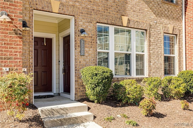 doorway to property featuring brick siding