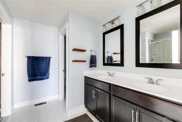 bathroom featuring double vanity, visible vents, a shower stall, and a sink