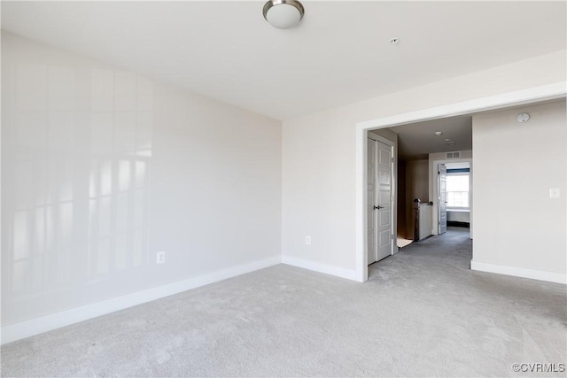 spare room with baseboards and carpet