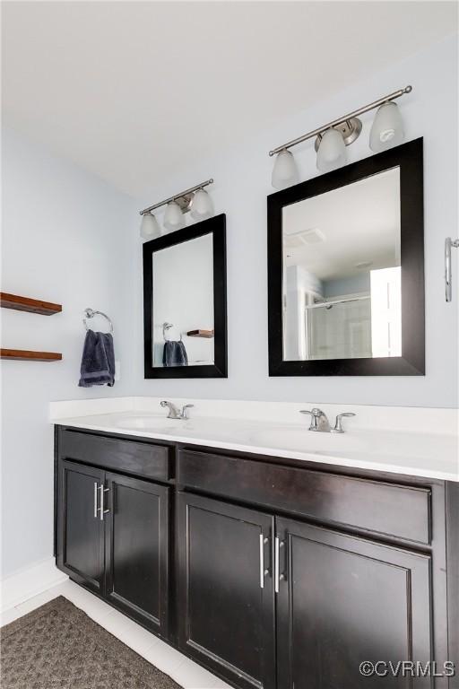 bathroom with double vanity, tile patterned floors, and a sink