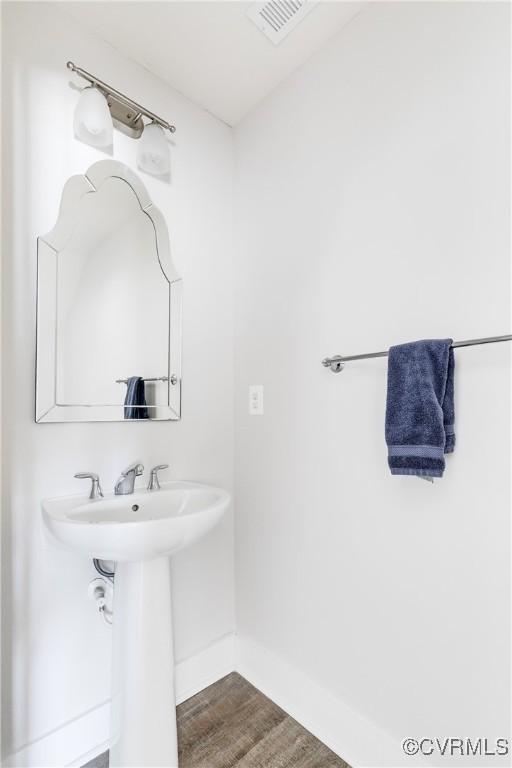 bathroom featuring wood finished floors, visible vents, and baseboards