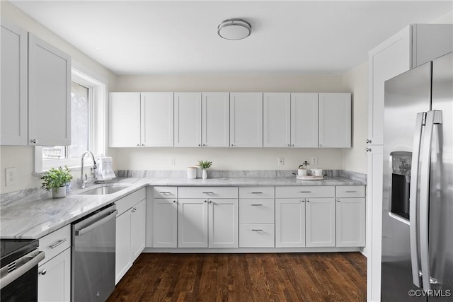 kitchen featuring light stone countertops, stainless steel appliances, dark wood-style floors, white cabinetry, and a sink