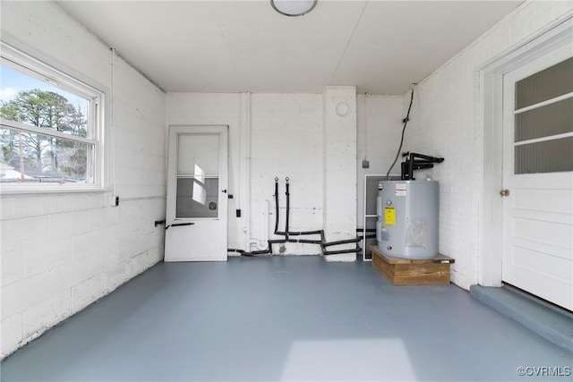 garage featuring electric water heater and concrete block wall