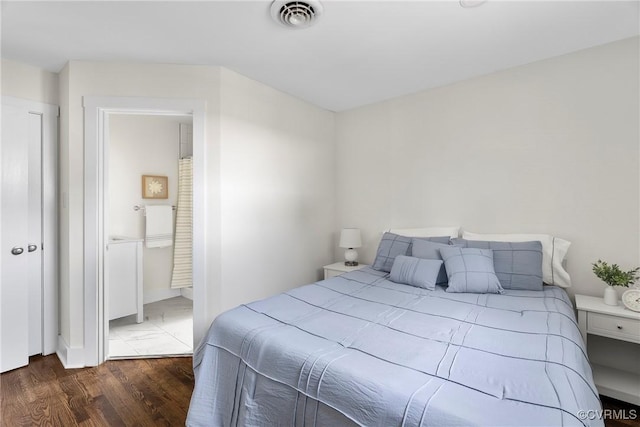 bedroom featuring wood finished floors and visible vents