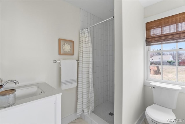 full bathroom with a shower stall, toilet, baseboards, and a sink