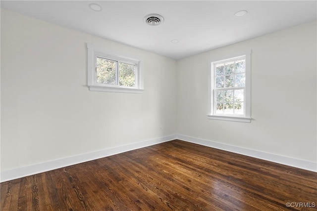 unfurnished room with dark wood finished floors, baseboards, and visible vents