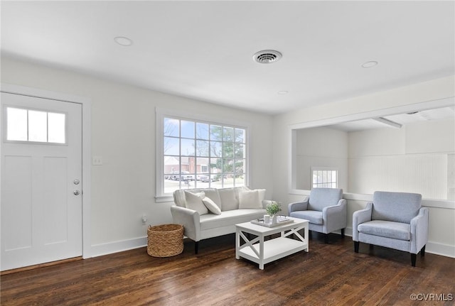 living room featuring visible vents, baseboards, and dark wood-type flooring