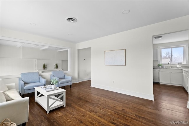 living room featuring visible vents, baseboards, and dark wood finished floors