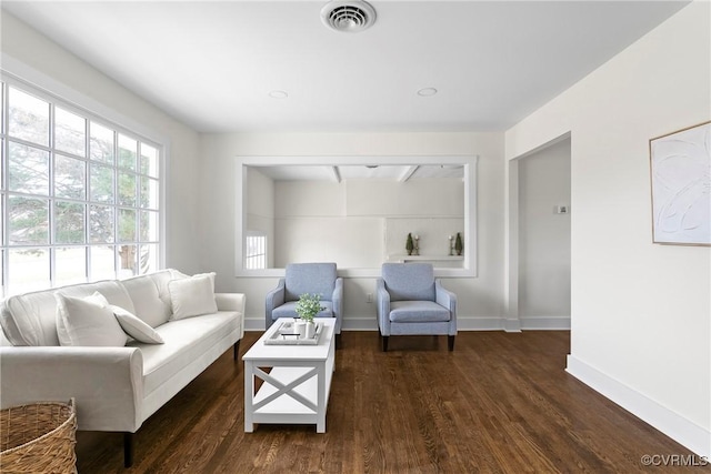 living room featuring visible vents, dark wood-type flooring, and baseboards