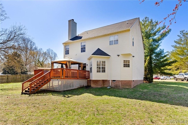 rear view of property with a deck, crawl space, a yard, and a chimney