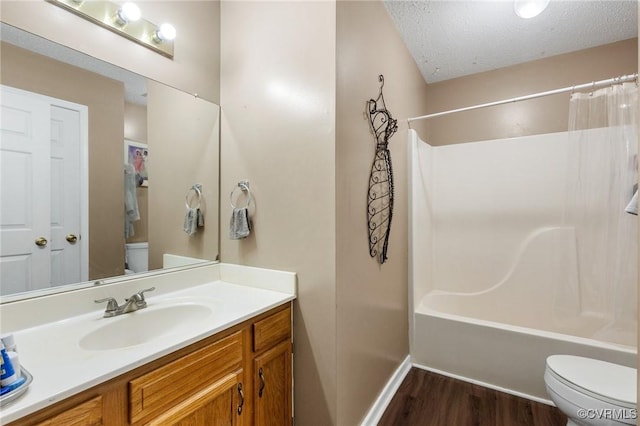 bathroom with toilet, vanity, shower / tub combo, wood finished floors, and a textured ceiling