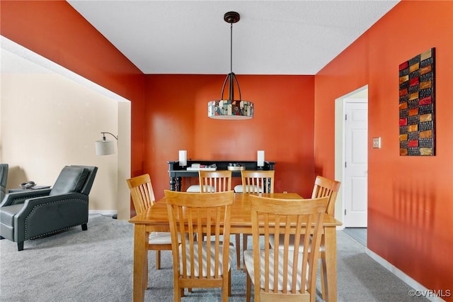 dining room featuring carpet flooring and baseboards