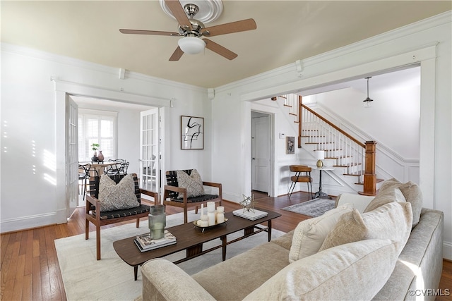 living room with hardwood / wood-style floors, stairs, ceiling fan, and ornamental molding