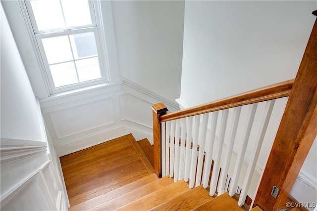 stairs with a decorative wall and wainscoting