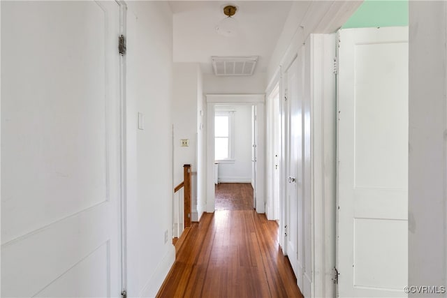 corridor featuring an upstairs landing, visible vents, baseboards, and hardwood / wood-style floors