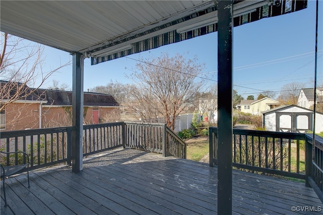 deck featuring an outbuilding, a storage shed, and fence