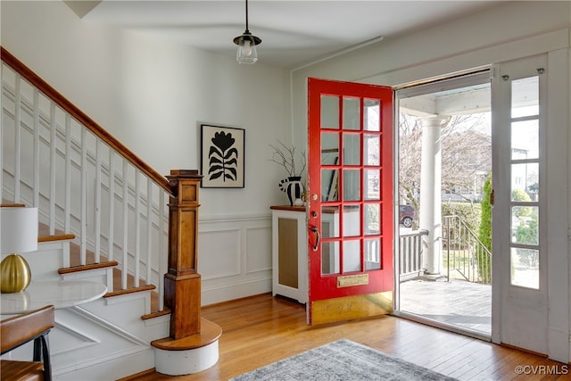 foyer featuring hardwood / wood-style flooring, a decorative wall, plenty of natural light, and a wainscoted wall