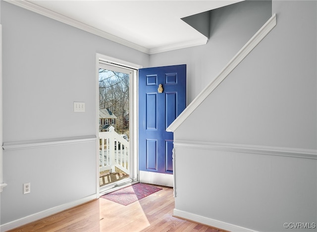 foyer featuring crown molding, baseboards, and wood finished floors