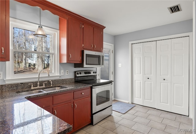 kitchen with visible vents, baseboards, appliances with stainless steel finishes, hanging light fixtures, and a sink