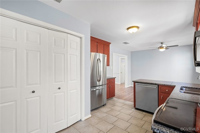 kitchen with visible vents, a peninsula, a sink, ceiling fan, and stainless steel appliances