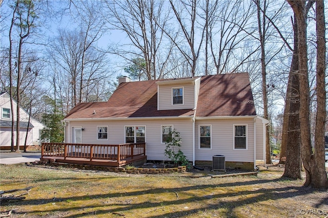 rear view of house with crawl space, a chimney, a wooden deck, and a yard