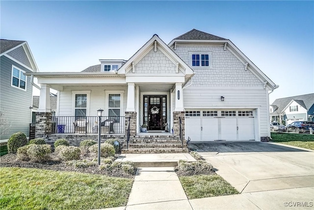 craftsman inspired home featuring a porch, concrete driveway, and a garage