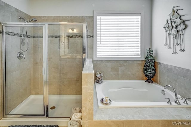 bathroom with a shower stall and a bath