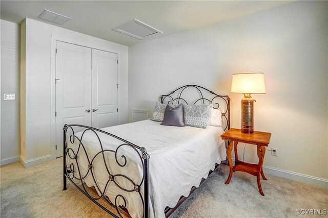 bedroom featuring attic access, light colored carpet, a closet, and baseboards