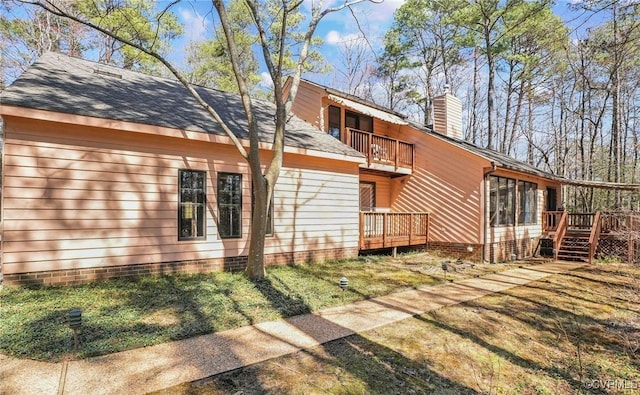 back of property featuring a balcony, a wooden deck, a shingled roof, a chimney, and crawl space