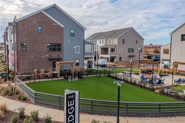 view of home's community featuring a pergola, a yard, and fence