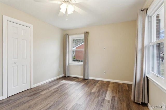 spare room with a ceiling fan, baseboards, and wood finished floors