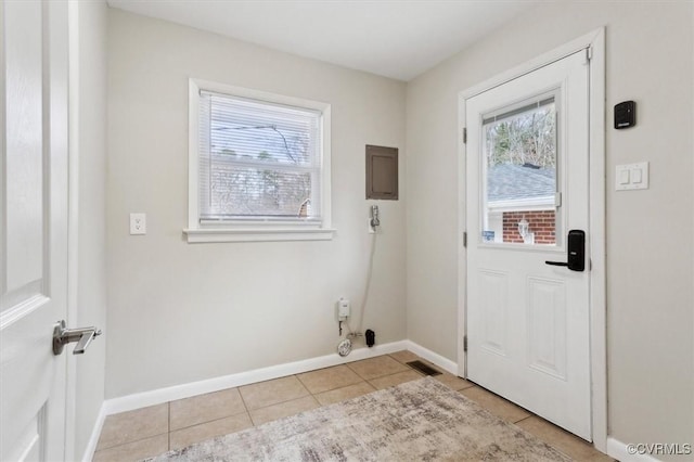 doorway to outside with baseboards, a healthy amount of sunlight, and light tile patterned flooring